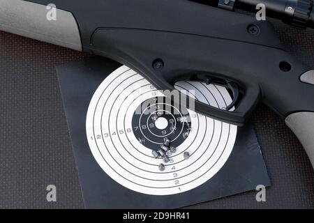 top view of air gun, paper shooting target with bullet holes and airgun pellets Stock Photo