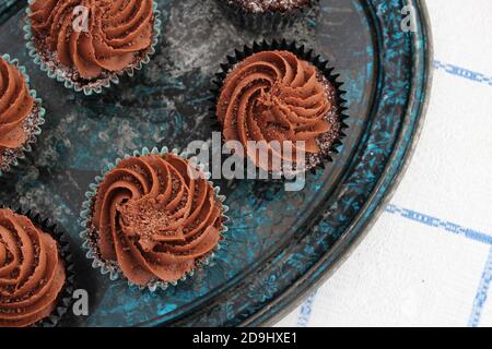 Cocolate cupcakes with chocolate frosting and grated chocolate on a rustic plate Stock Photo