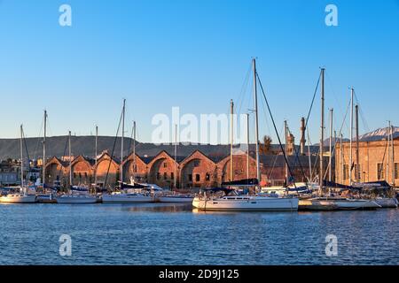 Sunrise in Old Venetian port, Chania, Crete, Greece. Sailing boats, yachts, pier, Old Venetian shipyard. Bell tower of Greek church, Cretan mountains Stock Photo