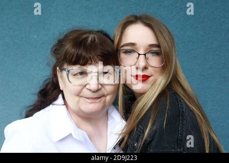 Portrait of grandmother with granddaughter on wall background Stock Photo
