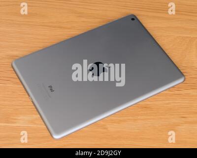 Underside of iPad Air 1 Tablet Computer on wooden desk showing grey satin anodised Aluminium finish Stock Photo