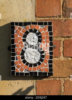 Closeup of small , pretty, number eight (8) mosaic tile house number sign, UK Stock Photo