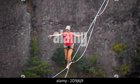 A slacking participant walks on a tight rope in the air at the 2020 Slacking Tournament in  Shenxianju Scenic Area in Taizhou city, east China's Zheji Stock Photo