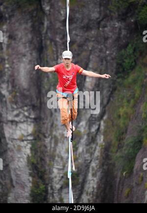 A slacking participant walks on a tight rope in the air at the 2020 Slacking Tournament in  Shenxianju Scenic Area in Taizhou city, east China's Zheji Stock Photo