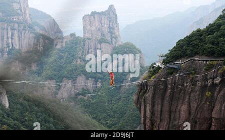 A slacking participant walks on a tight rope in the air at the 2020 Slacking Tournament in  Shenxianju Scenic Area in Taizhou city, east China's Zheji Stock Photo