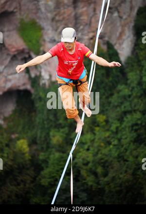 A slacking participant walks on a tight rope in the air at the 2020 Slacking Tournament in  Shenxianju Scenic Area in Taizhou city, east China's Zheji Stock Photo