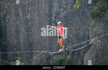 A slacking participant walks on a tight rope in the air at the 2020 Slacking Tournament in  Shenxianju Scenic Area in Taizhou city, east China's Zheji Stock Photo