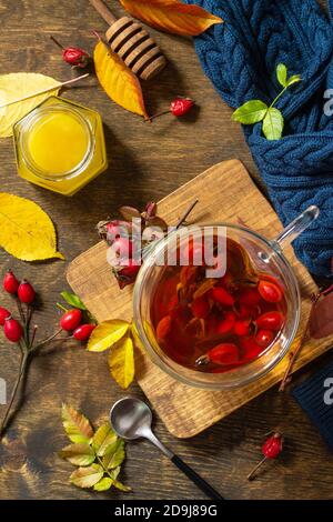 Healthy winter vitamin drink. Hot rosehip tea with honey and dried fruits on a wooden table top. Top view flat lay background. Stock Photo