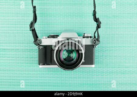Vintage film camera on an aqua blue background. Stock Photo