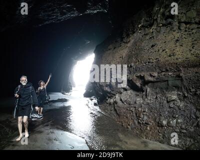 AUCKLAND, NEW ZEALAND - Nov 24, 2019: Auckland / New Zealand - November 24 2019: View of Piha Blowhole cave with photographers Stock Photo