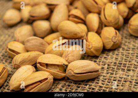 Salted pistachios lie on the burlap. Close up Stock Photo