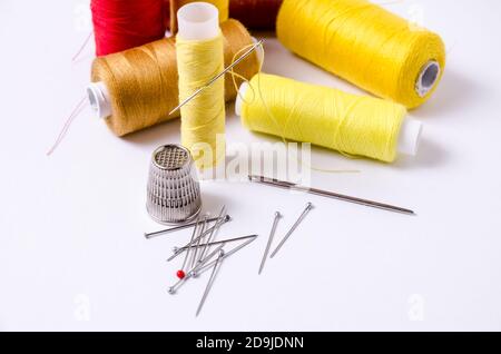 Spool of dark, black thread with needle and one metal thimble on white  background, home crafting, sewing kit, indoors, close-up Stock Photo - Alamy