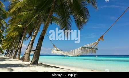 Beautiful tropical island with sand beach and hammock. Panglao, Philippines. Seascape with beautiful beach and palm trees. Stock Photo