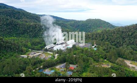 Aerial drone of Geotermal power plant on Mount Apo. Geothermal station with steam and pipes in the rainforest. Mindanao, Philippines. Stock Photo