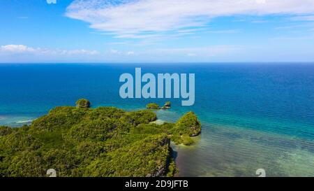 Aerial view of the mountains covered with jungle, blue sea and sky with clouds. Bohol,Philippines. Stock Photo