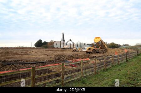 Heavy machinery at work near the thirteenth century St. Mary's Church in Sevington, Ashford, Kent, as the government develops the 27-acre site near the town into a post-Brexit lorry park as efforts continue to strike a trade deal with the European Union. Stock Photo