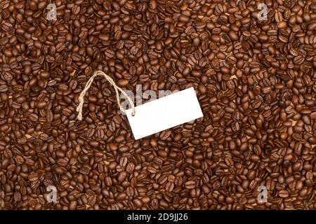 Texture of coffee grains in a top view with a blank white label Stock Photo