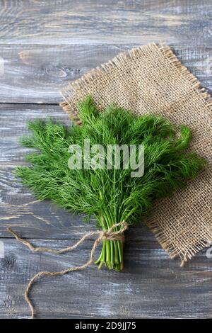 Bunch of fresh dill on a wooden surface. Rustic style, selective focus Stock Photo