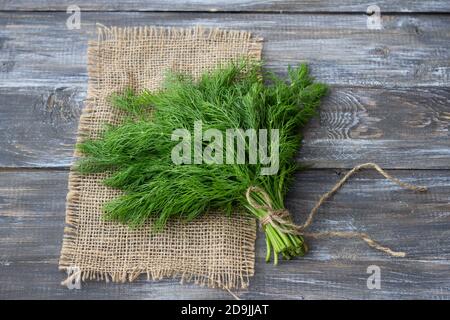 Bunch of fresh dill on a wooden surface. Rustic style, selective focus Stock Photo