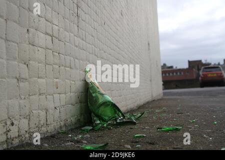 A bottle of Buckfast Tonic Wine, or 'Buckie' as it is known locally, lies broken on the pavement. Stock Photo