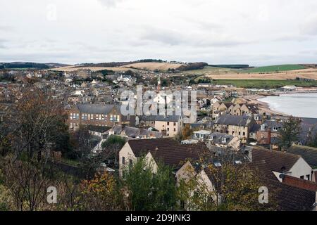 Elevated aerial image of town centre, Stonehaven, Aberdeenshire, Scotland, UK with beach, calm sea, background fields and cloudy sky. Stock Photo