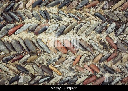 background of fine river stone, pavement lined with stone Stock Photo