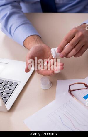 Sick male employee suffering at the workplace Stock Photo