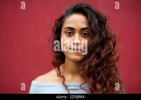 Close up portrait beautiful young Indian woman with long hair biting lip