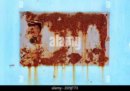 rusty trace of the plaque on a metal door with peeling paint Stock Photo