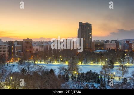 Wintery city skyline in Sapporo, Japan  over looking Nakajima Park at dawn. Stock Photo