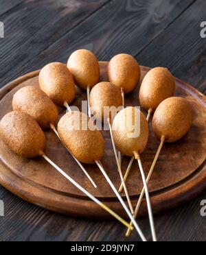Bunch of mini corn dogs on wooden board Stock Photo