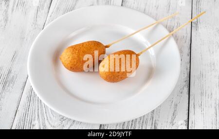 Bunch of mini corn dogs on white plate Stock Photo