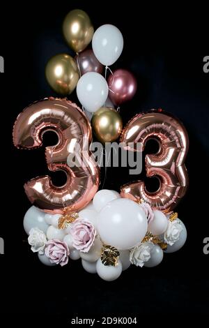 birthday card. Congratulations to 33 years old. Composition of balls and flowers on a black background. Stock Photo