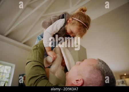 Young father lifting child in air while playing at home Stock Photo