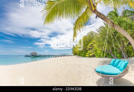 Tropical beach background as summer landscape with beach swing or hammock and white sand and calm sea for beach banner. Perfect beach scene vacation