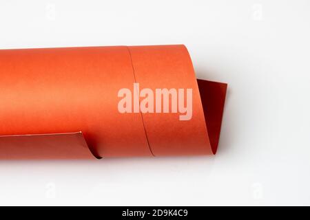 Isolated rolled red textured art paper on white background Stock Photo