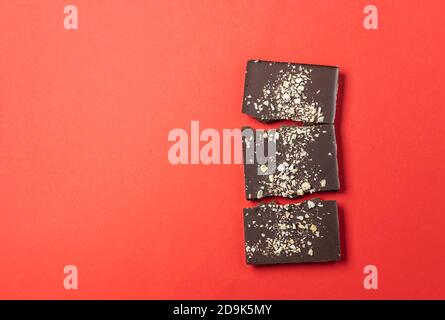 Handmade chocolate bars with berries on a red background. View from above. Stock Photo