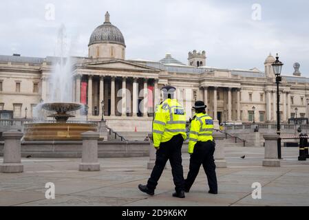 Police officers patrolling the beat in London, UK, on the first day of the second COVID-19 national lockdown, in Trafalgar Square. C19 protest risk Stock Photo