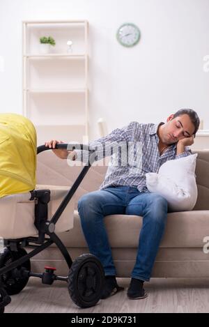 Young father looking after newborn baby at the home Stock Photo