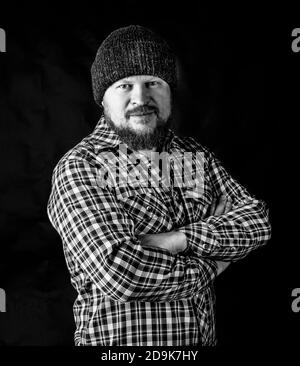 Solid bearded man in a wool cap portrait on black background Stock Photo