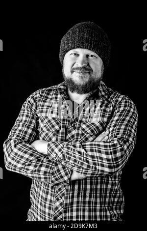 Solid bearded man in a wool cap portrait on black background Stock Photo