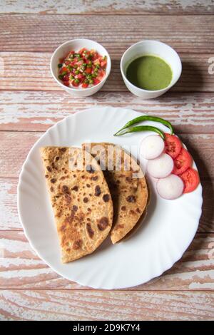 Top view of alu paratha or potato stuffed Indian bread along with condiments Stock Photo