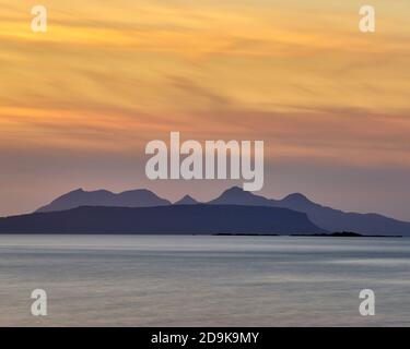 Sunset over the the Small Isles of Rhum and Eigg, viewed from near Glenuig, Moidart, Lochaber, Highland, Scotland. Stock Photo