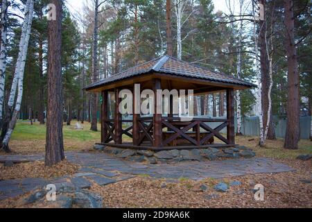 a brown wooden gazebo for relaxing in the forest. Stock Photo