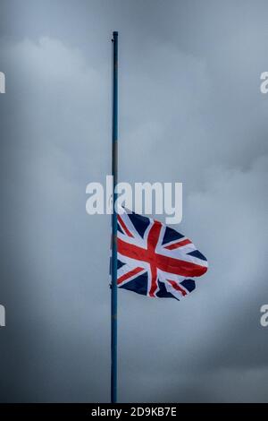 A british Union Flag flies at half mast to mark the passing of one of their members on a dark and rainy winter’s day from the roof of a Royal British Legion club in Bournemouth, Dorset. 10 January 2014. Photo: Neil Turner Stock Photo