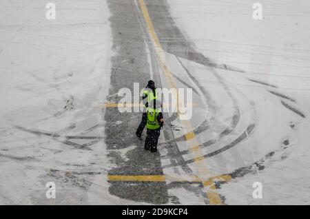 Airport Workers Having a Conversation While Waiting for the Airplane in Bad Winter Weather with a lot of Snow. JFK Airport, New York, USA Stock Photo