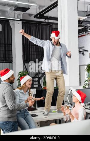 Multiethnic businesspeople holding glasses of champagne while celebrating new year in office Stock Photo