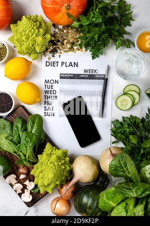 Lose weight concept. Smartphone Diet plan and set of healthy food Stock Photo