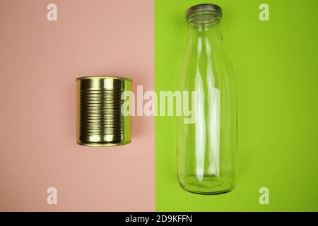 Top view on isolated metal can and glass bottle, pink and green Background - waste separation and recycling concept Stock Photo