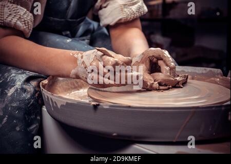 The process of making a clay pot on a potter's wheel. Close-up. Stock Photo